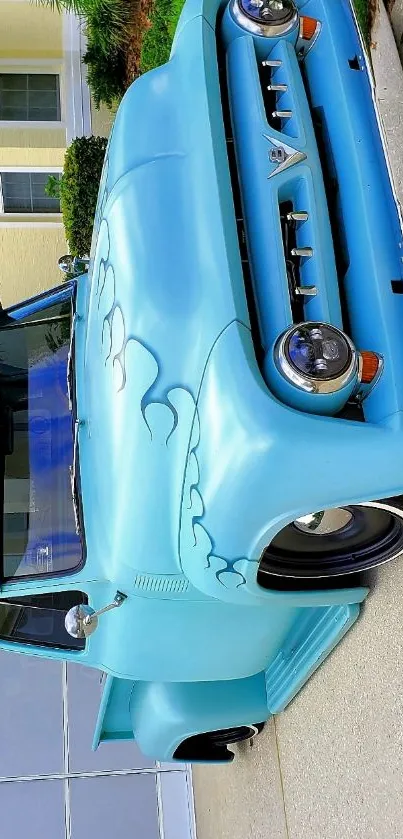 Vintage blue truck parked by house on pavement.