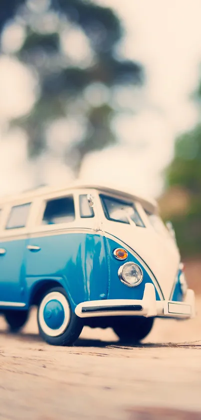 Vintage blue van on a rustic wooden path with blurry forest background.