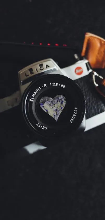 Vintage camera with heart detail on lens, set against a black background.