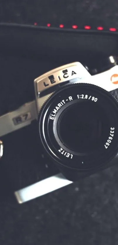 Vintage Leica camera with leather strap on dark background wallpaper.