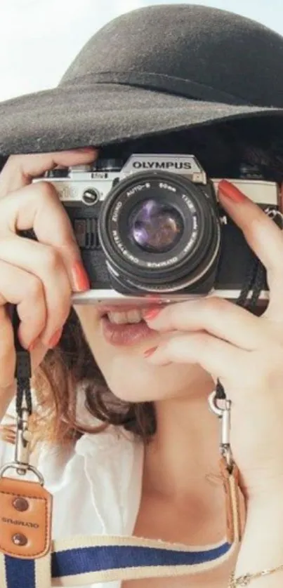 Woman with vintage camera and black hat.