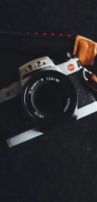 Close-up of vintage camera on dark background with leather strap.