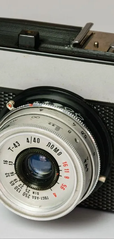 Close-up of vintage camera with lens focus on gray background.