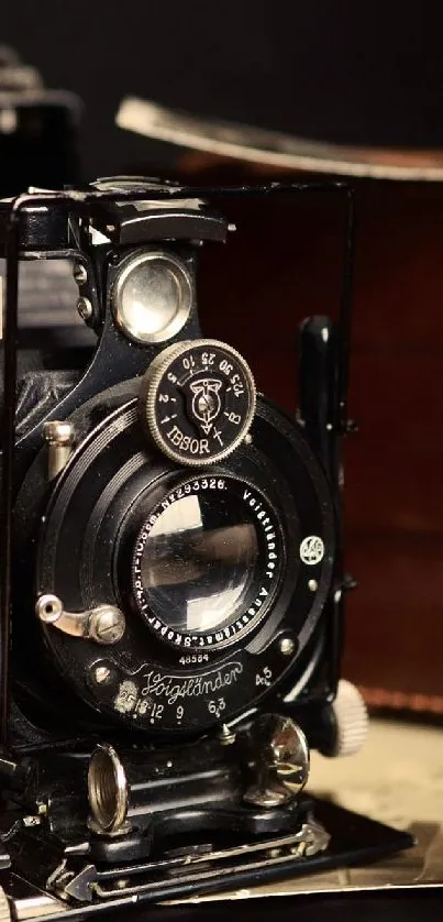 Vintage camera and leather case with photos on dark background.