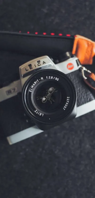 Vintage camera on a textured dark gray background with leather strap.