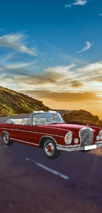 Vintage red convertible on a scenic mountain road at sunset.