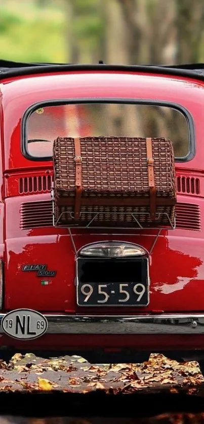 Classic red car on autumn road with vintage appeal.