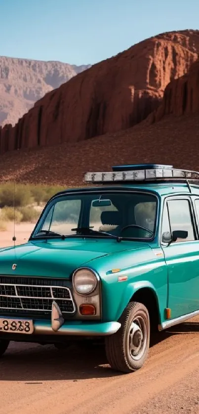 Vintage teal car driving through a desert landscape with mountains and trees.