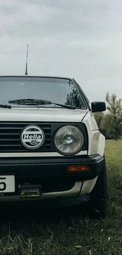 A vintage car parked in a serene countryside setting.