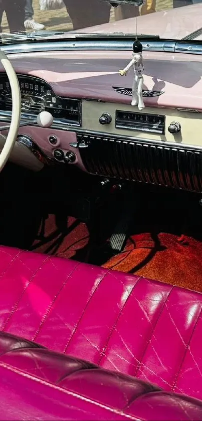 Vintage car with pink interior and classic dashboard.