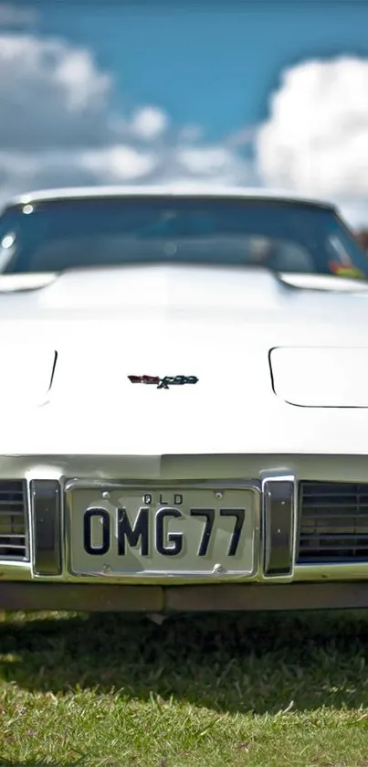 A classic white muscle car set against a bright, cloudy sky.