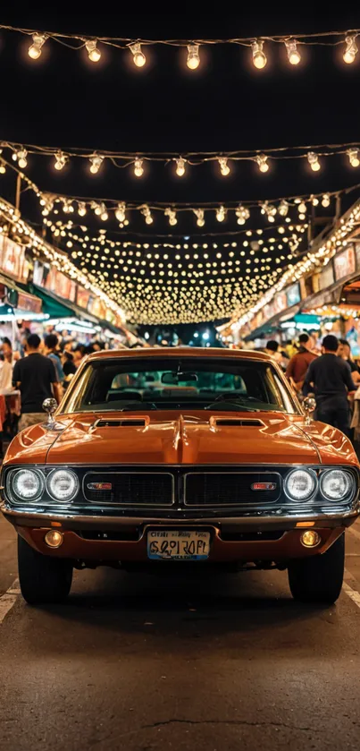 Vintage car at night market with string lights overhead.