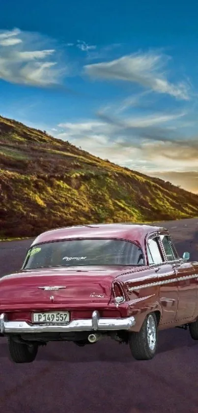 Vintage car on winding mountain road under a vibrant blue sky.