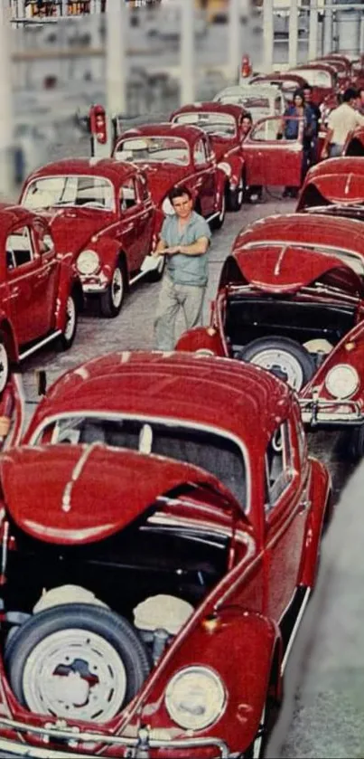 Vintage red cars in a factory line setting, showcasing classic automotive design.