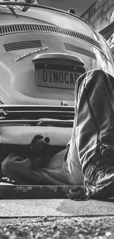 Monochrome photo of a vintage car being repaired.