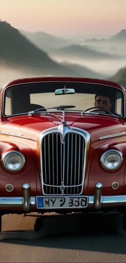 Vintage red car driving through a scenic misty road.