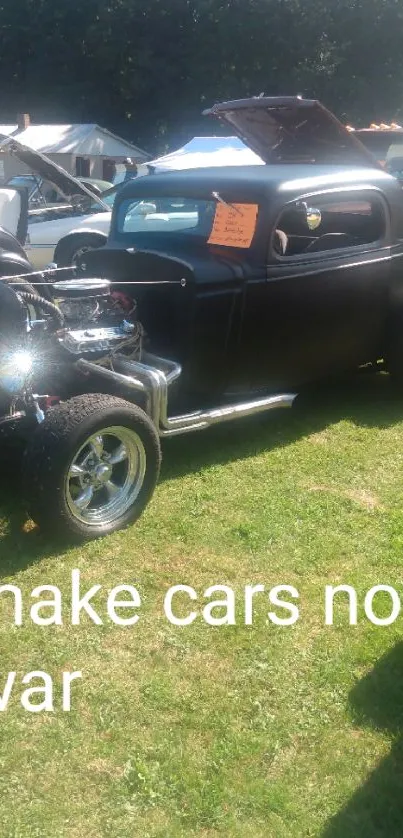 Vintage car show featuring a black hot rod on green grass.