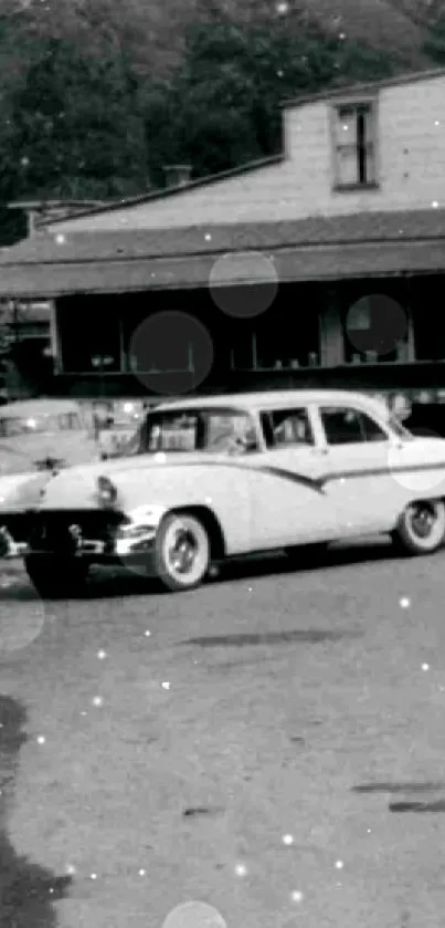 Vintage car parked on a historic street in black and white.