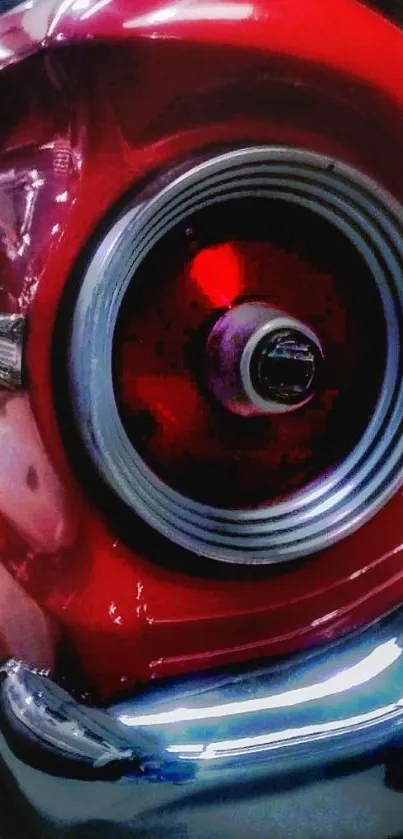 Close-up of a vintage car's red tail light with chrome details.