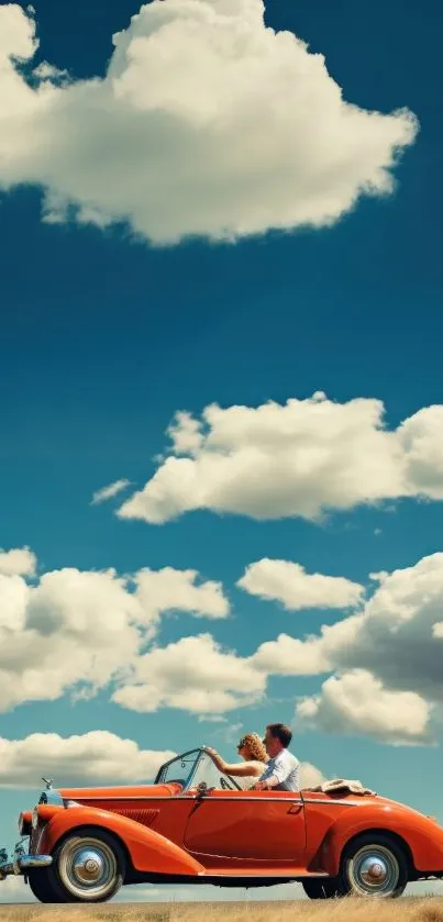 Vintage red car on road beneath vibrant blue sky with clouds.