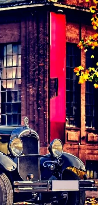 Vintage car parked by a brick building with autumn leaves.