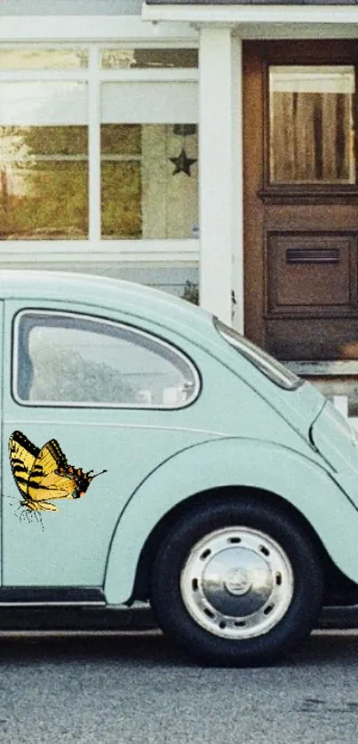 Vintage car with butterfly art on the side, set outside a house.