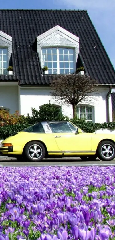 Vintage yellow car with purple flowers next to a white house.