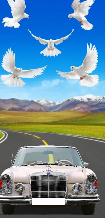 Vintage car with doves soaring in a blue sky over a mountain road.