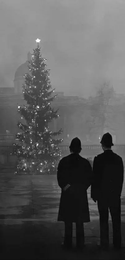 Vintage black and white wallpaper of a lit Christmas tree in a foggy city square.