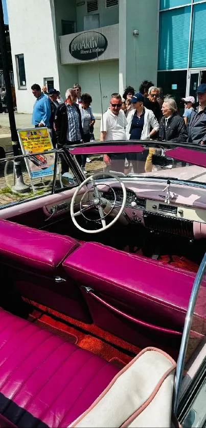 Vintage car with purple interior at urban event.