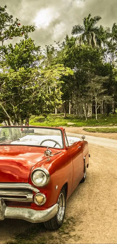 Red vintage convertible on a picturesque countryside road.
