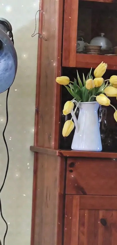 Rustic cabinet with yellow tulips in vase and vintage lamp.