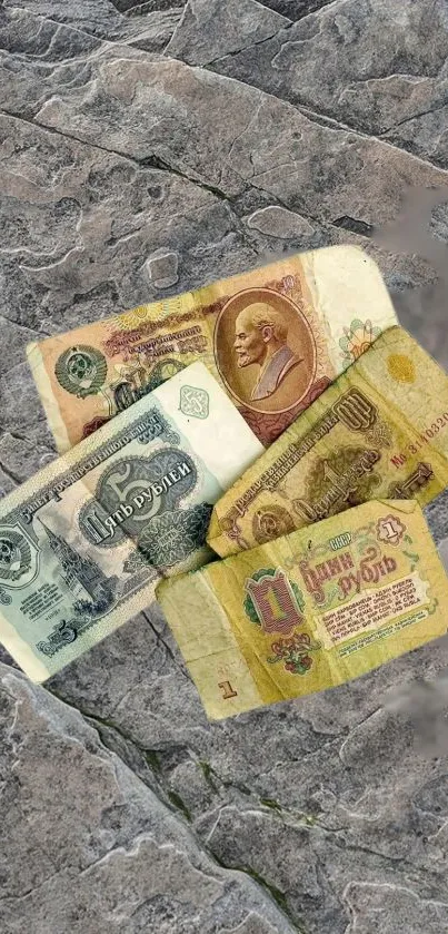 Vintage currency bills on a textured stone background.