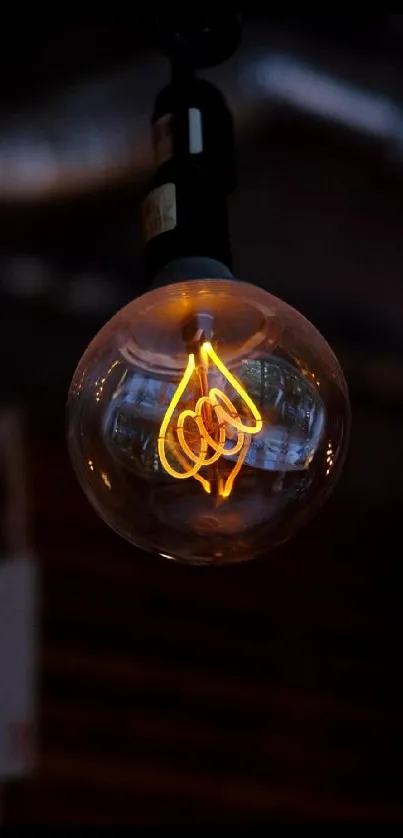 Vintage Edison bulb with glowing filament on dark background.