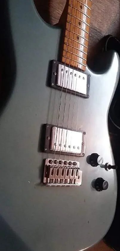 Vintage electric guitar with dark finish on wooden floor.