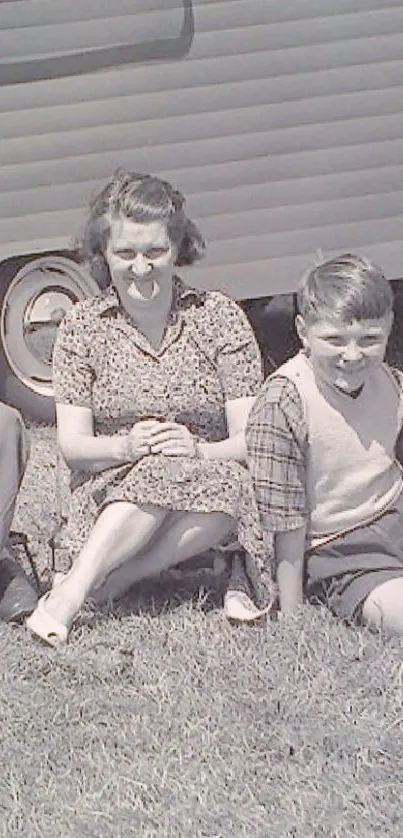 Vintage family photo with caravan backdrop in grayscale.