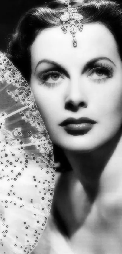 Vintage black and white portrait of a glamorous woman with elegant headpiece.