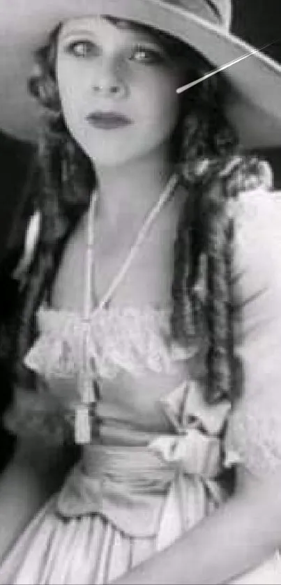 Vintage black and white photo of a lady in an elegant hat and dress.