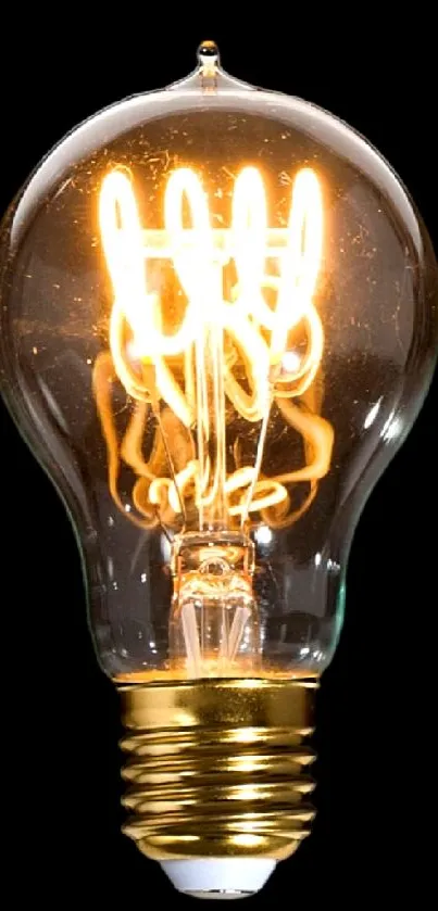 Vintage light bulb with glowing filaments on a black backdrop.