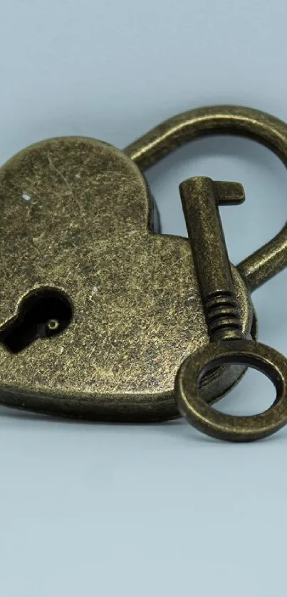 Vintage brass heart-shaped lock with key on plain background.