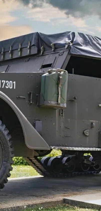 A vintage military vehicle parked outdoors under a cloudy sky.