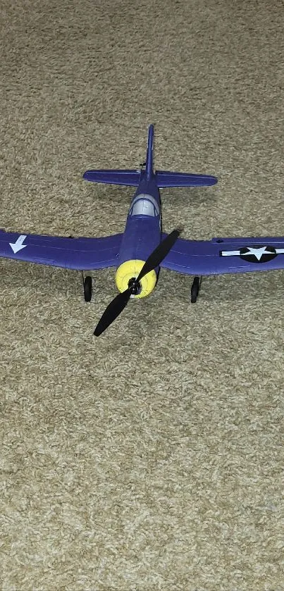 Blue vintage model airplane on tan carpet.