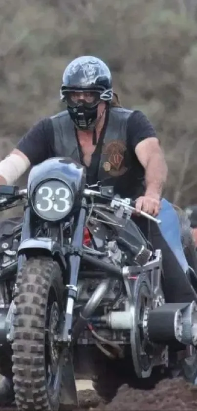 Man riding a vintage motorcycle on rough terrain, wearing a black helmet.