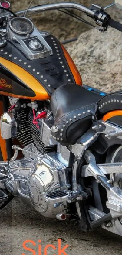 Vintage motorcycle with orange accents on rugged terrain background.