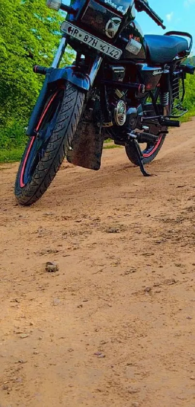 Vintage motorcycle on a dirt road with lush greenery background.