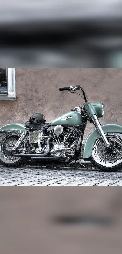 Vintage motorcycle with sage green color against a rustic wall.