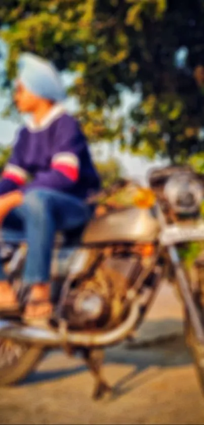 Man sitting on a vintage motorcycle in a blurry, scenic outdoor setting.