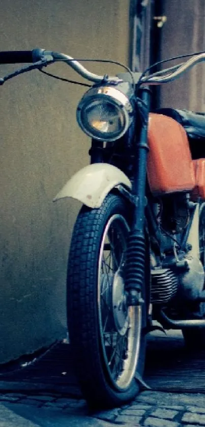 Vintage motorcycle on cobblestone street in an urban setting.