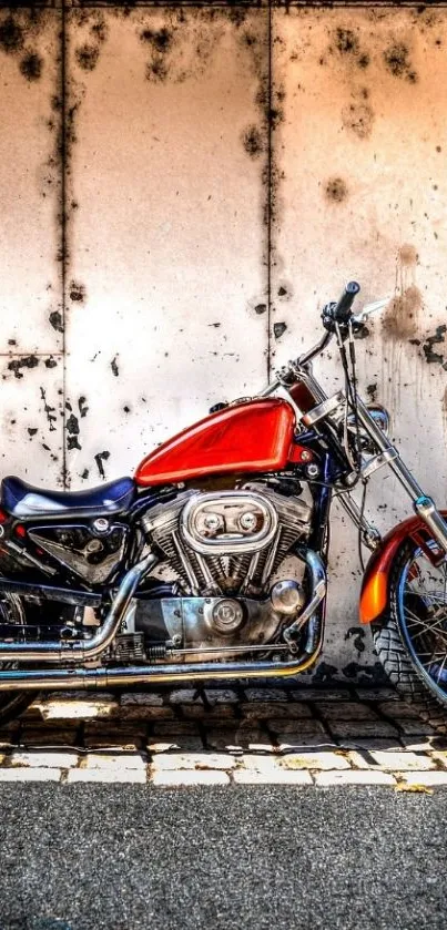 A vintage red motorcycle against an urban wall.