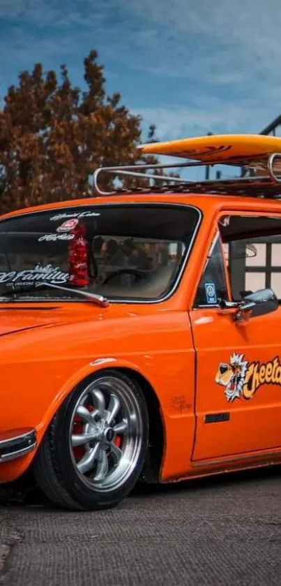 Vintage orange car with surfboard.